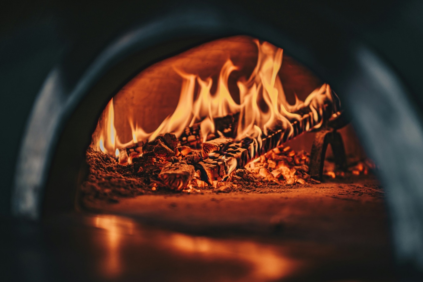 An artisanal margherita pizza on a rustic board by the oven.