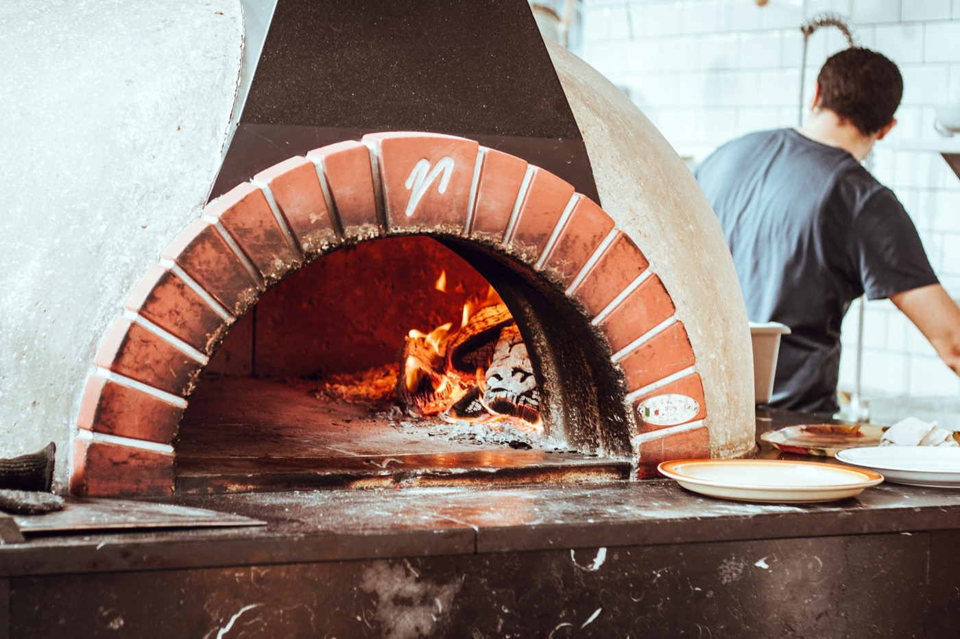 A wood-fired pizza plated and ready to serve.